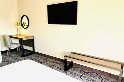 a room with a bed and a desk and a television at Ramada by Wyndham Modesto Yosemite Area in Modesto