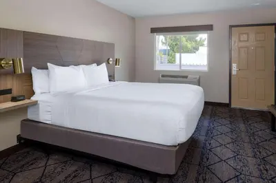 a large white bed in a hotel room at Ramada by Wyndham Modesto Yosemite Area in Modesto