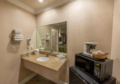 a bathroom with a sink with a microwave and a microwave at Edge Water Inn in Reedley