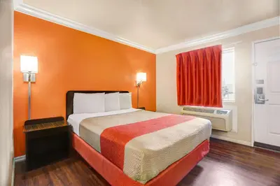 a hotel room with a bed and a red window at Motel 6-Fresno, CA - Belmont Ave in Fresno