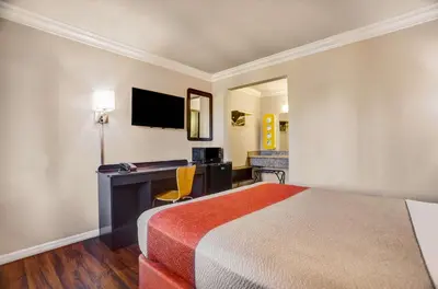 a hotel room with a bed and a desk at Motel 6-Fresno, CA - Belmont Ave in Fresno