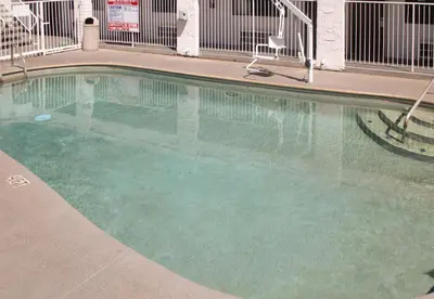 a swimming pool in a building with green water at Motel 6-Fresno, CA in Fresno