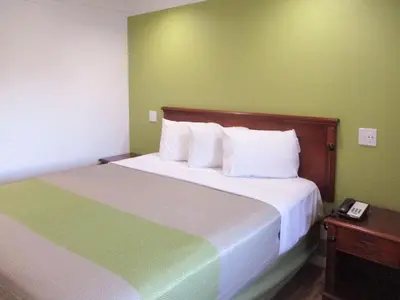 a hotel room with a bed with a phone on it at Motel 6-Fresno, CA in Fresno