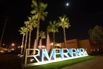 a large sign in front of palm trees at night at Summerfield Inn Fresno Yosemite in Fresno
