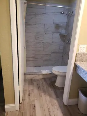 a bathroom with a shower and a toilet in it at University Inn Fresno in Fresno