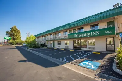 an empty parking lot in front of a university inn at University Inn Fresno in Fresno