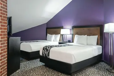 two beds in a hotel room with purple walls at La Quinta Inn by Wyndham Livermore in Livermore