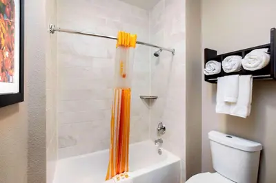 an orange shower curtain in a bathroom with a toilet at La Quinta Inn by Wyndham Livermore in Livermore