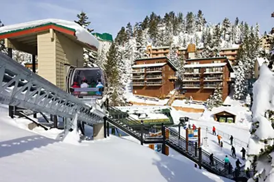 a ski lodge in the snow next to a building at Holiday Inn Club Vacations - Tahoe Ridge Resort in Stateline