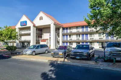 a hotel with cars parked in front of it at Motel 6-Fresno, CA - Yosemite Hwy in Pinedale
