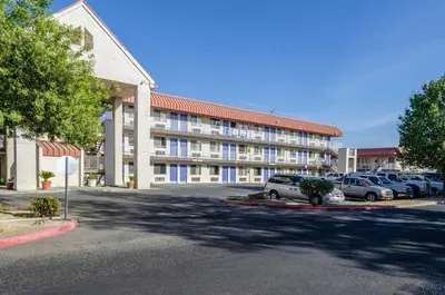 a large building with cars parked in a parking lot at Motel 6-Fresno, CA - Yosemite Hwy in Pinedale