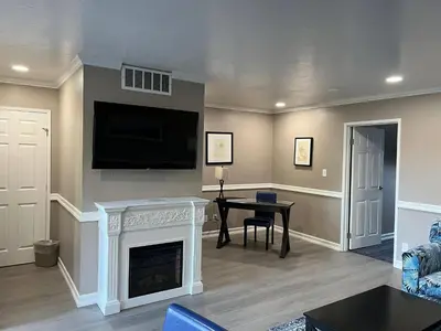 a living room with a fireplace and a flat screen tv at Lamp Liter Inn Visalia, an Ascend Collection Hotel in Visalia
