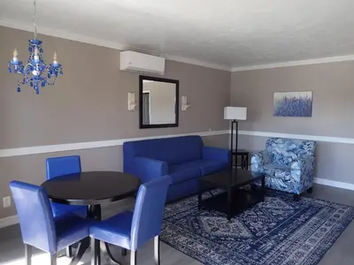 a living room with a blue couch and a table at Lamp Liter Inn Visalia, an Ascend Collection Hotel in Visalia