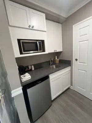 a small kitchen with a sink and a microwave at Lamp Liter Inn Visalia, an Ascend Collection Hotel in Visalia