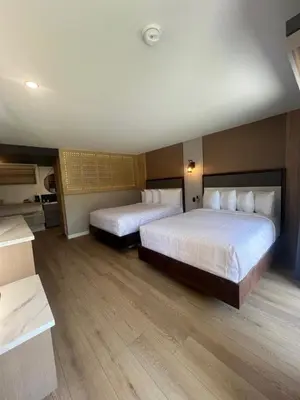 two beds in a hotel room with wooden floors at Lamp Liter Inn Visalia, an Ascend Collection Hotel in Visalia
