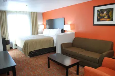 a hotel room with a bed and a couch at Quality Inn & Suites Fresno Northwest in Fresno