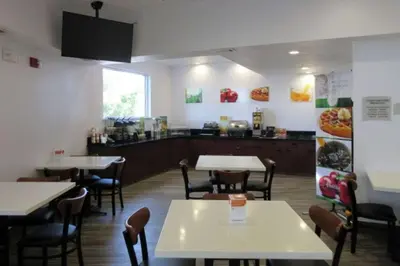 a restaurant with tables and chairs and a counter at Quality Inn & Suites Fresno Northwest in Fresno