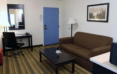 a living room with a couch and a desk and a blue door at Best Western Visalia Hotel in Visalia