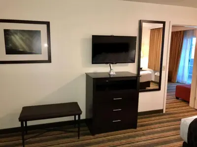 a room with a tv and a stool and a mirror at Best Western Visalia Hotel in Visalia
