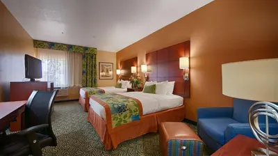 a hotel room with two beds and a couch at Best Western PLUS Fresno Inn in Fresno
