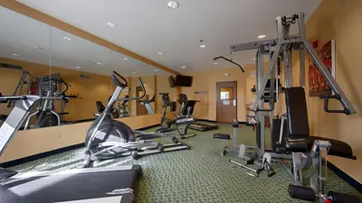 a gym with several exercise equipment in a room at Best Western PLUS Fresno Inn in Fresno