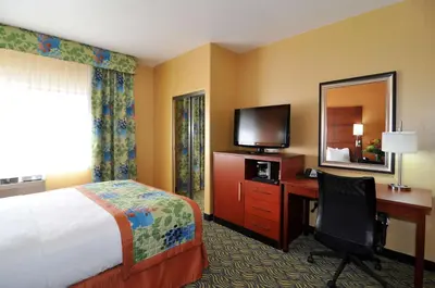 a hotel room with a bed and a desk and a television at Best Western PLUS Fresno Inn in Fresno