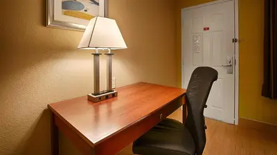 a desk with a lamp and a chair in a room at Best Western PLUS Fresno Inn in Fresno