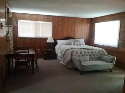 a bedroom with a bed and a chair and a table at The Tamarack Lodge in Lakeshore