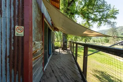 a porch with a hammock on the side of a building at Hawk's Rest in Oakhurst