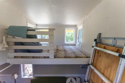 a small room with two bunk beds in a tiny house at Little Red Caboose in Oakhurst