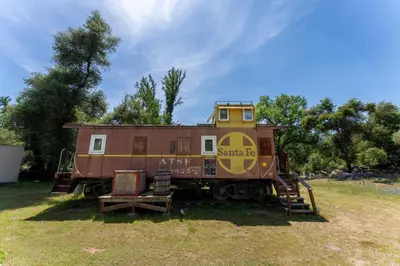 an old train car sitting in a field at Little Red Caboose in Oakhurst