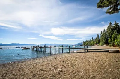 a beach with a pier and a boat in the water at Tahoma Getaway in Tahoma
