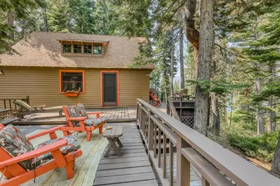a wooden deck with chairs and a house at The Cherry Leaf Lodge & Retreat on Fallen Leaf Lake in Fallen Leaf