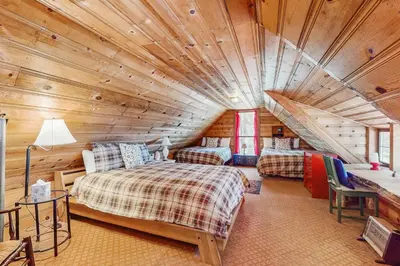 a bedroom in a log cabin with two beds at The Cherry Leaf Lodge & Retreat on Fallen Leaf Lake in Fallen Leaf