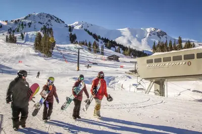 a group of people walking in the snow with snowboards at Wildflower 55 in Mammoth Lakes