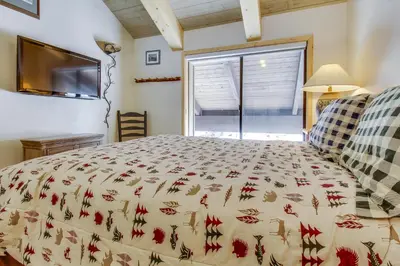 a bedroom with a bed and a tv and a window at Val D'Isere 45 in Mammoth Lakes