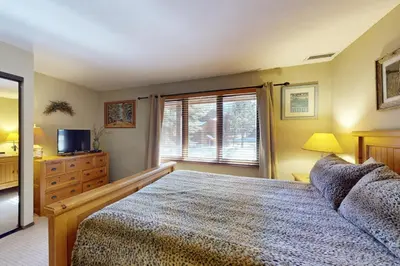a bedroom with a bed and a tv and a window at Woodlands 34 in Mammoth Lakes