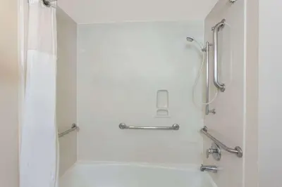 a white bathroom with a shower and a tub at Ramada by Wyndham Fresno Northwest in Fresno