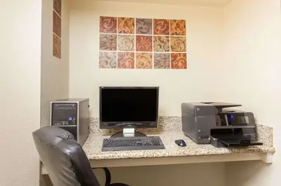 a desk with a computer and a printer on it at Ramada by Wyndham Fresno Northwest in Fresno