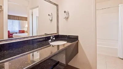 a bathroom with a sink and a mirror at Best Western Golden Key in Auburn