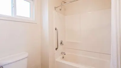 a white bathroom with a shower and a toilet at Best Western Golden Key in Auburn
