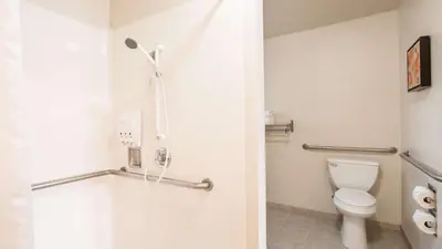 a bathroom with a toilet and a shower at Best Western Golden Key in Auburn