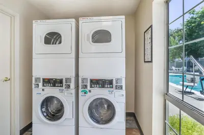 two washing machines in a laundry room with a window at Best Western Luxury Inn in Tracy