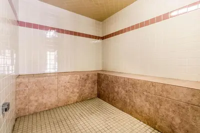 an empty shower room with a tiled floor at Comfort Inn Lathrop Stockton Airport in Lathrop
