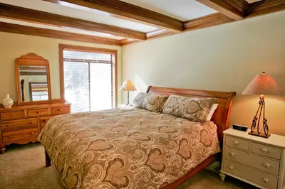 a bedroom with a bed and a dresser and a mirror at Silver Bear # 36 in Mammoth Lakes