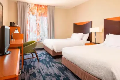 a hotel room with two beds and a desk and a television at Fairfield Inn & Suites by Marriott Selma Kingsburg in Kingsburg