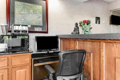 a kitchen with a desk with a computer and a chair at Knights Inn Madera in Madera
