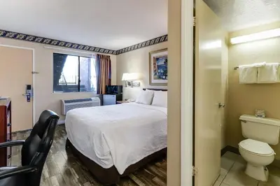 a hotel room with a bed and a toilet at Knights Inn Madera in Madera