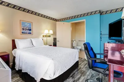 a hotel room with a bed and a chair at Knights Inn Madera in Madera