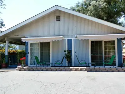 a house with green chairs on the porch at NEW CHARMING 2 BEDROOMS UNIT CLOSE TO EVERYTHING in Oakhurst